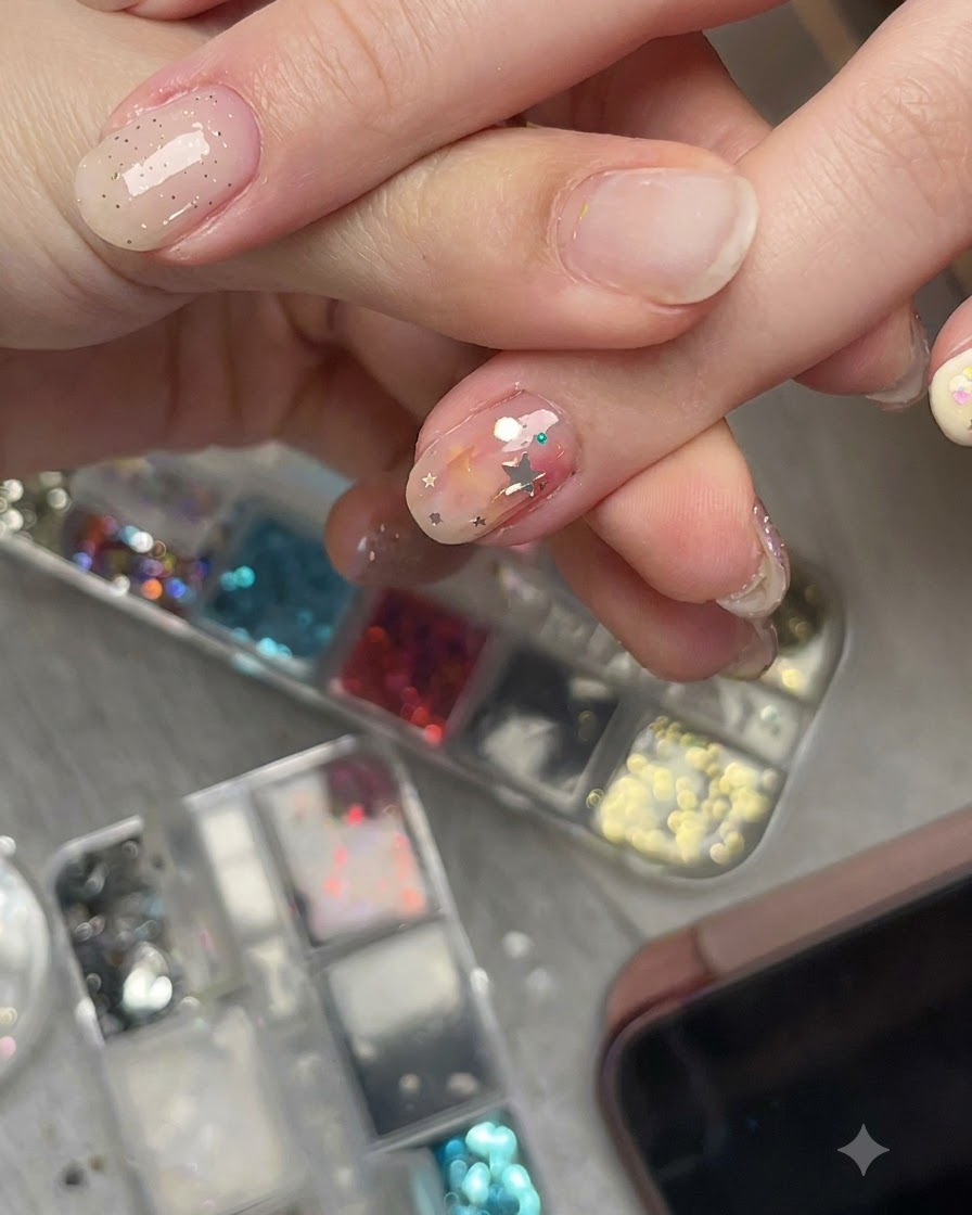 Un plan rapproché dune main visualisant une pièce de paillettes étoile pré-courbée sur un ongle sous un angle latéral pour montrer son ajustement parfait.