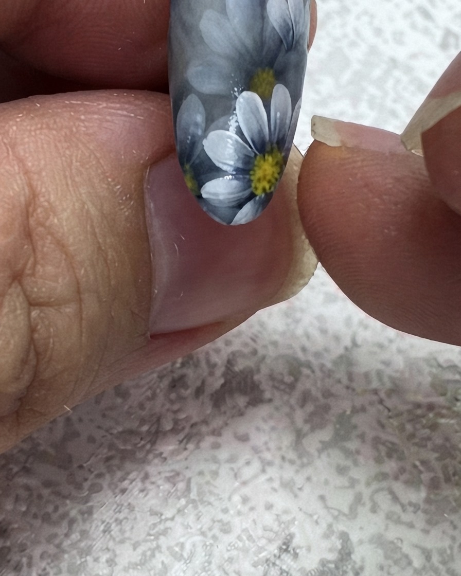 Un pinceau liner fin ajoutant une deuxième feuille verte dans le coin supérieur dun design dongle floral.