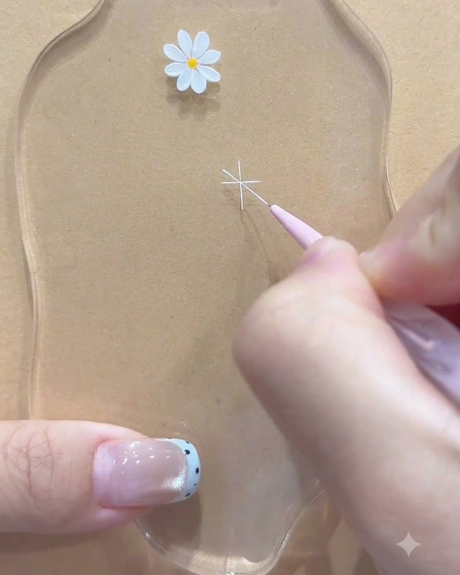 Un pinceau fin ajoutant des lignes blanches diagonales supplémentaires pour compléter le contour de la marguerite.