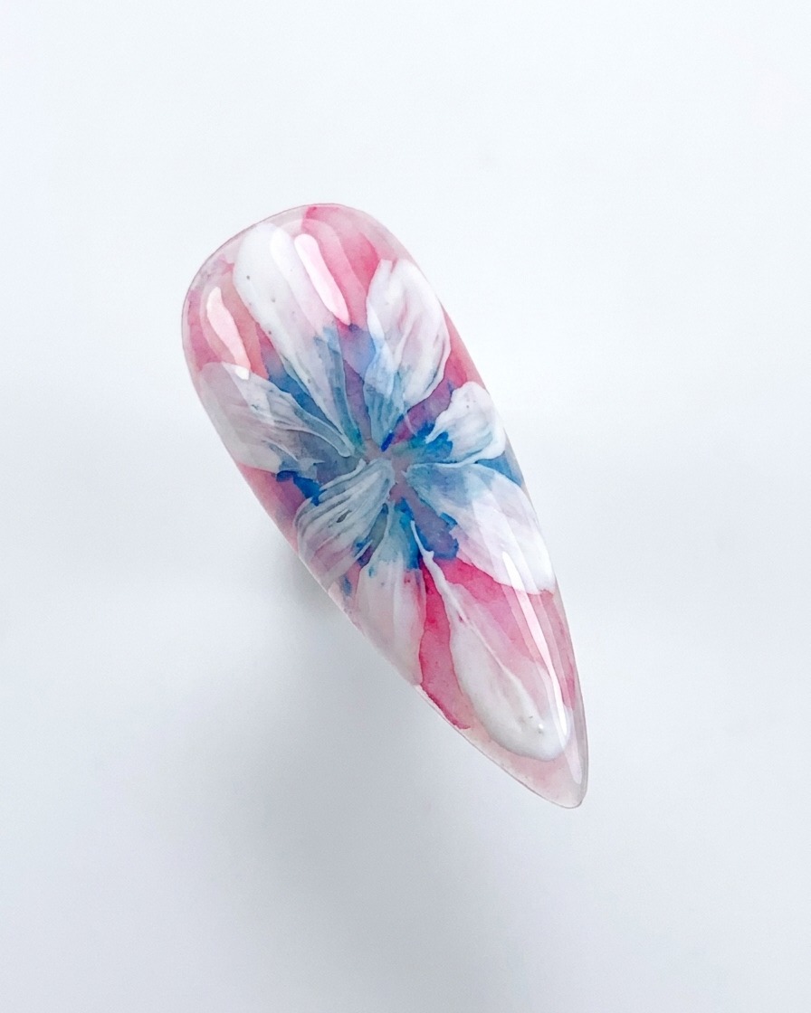 Une main plaçant un ongle décoré sous une lampe de catalyse UV/LED rose.