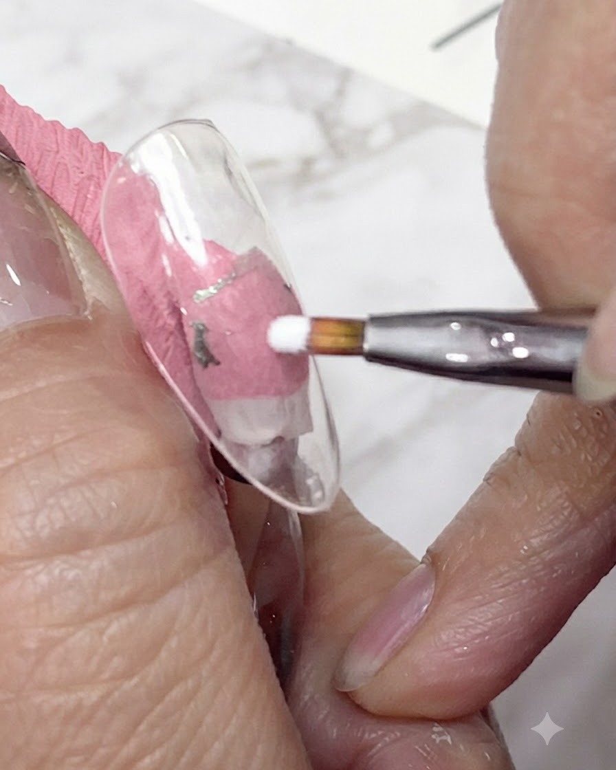 Un gros plan dun pinceau fin appliquant du gel blanc pour former les premiers pétales dune marguerite sur une capsule dongle transparente.