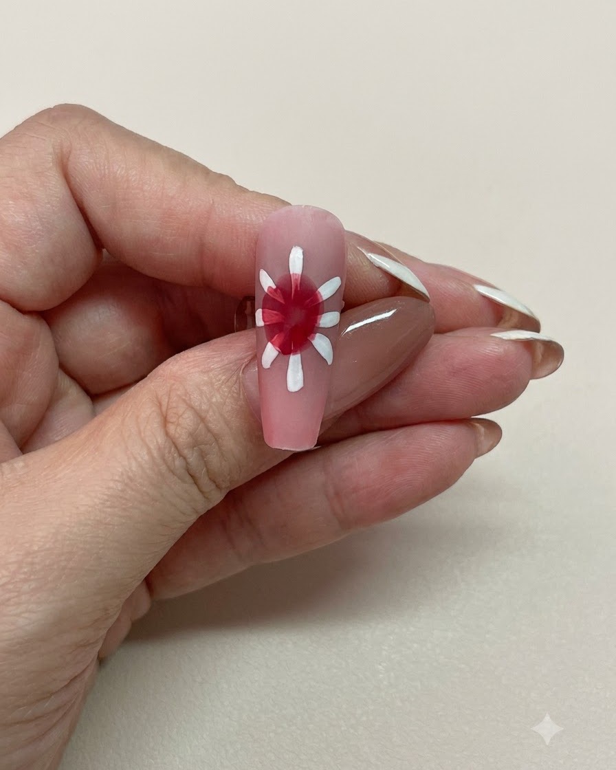Vue rapprochée dun ongle rose avec un centre blooming rouge doucement diffus entouré de pétales blancs.