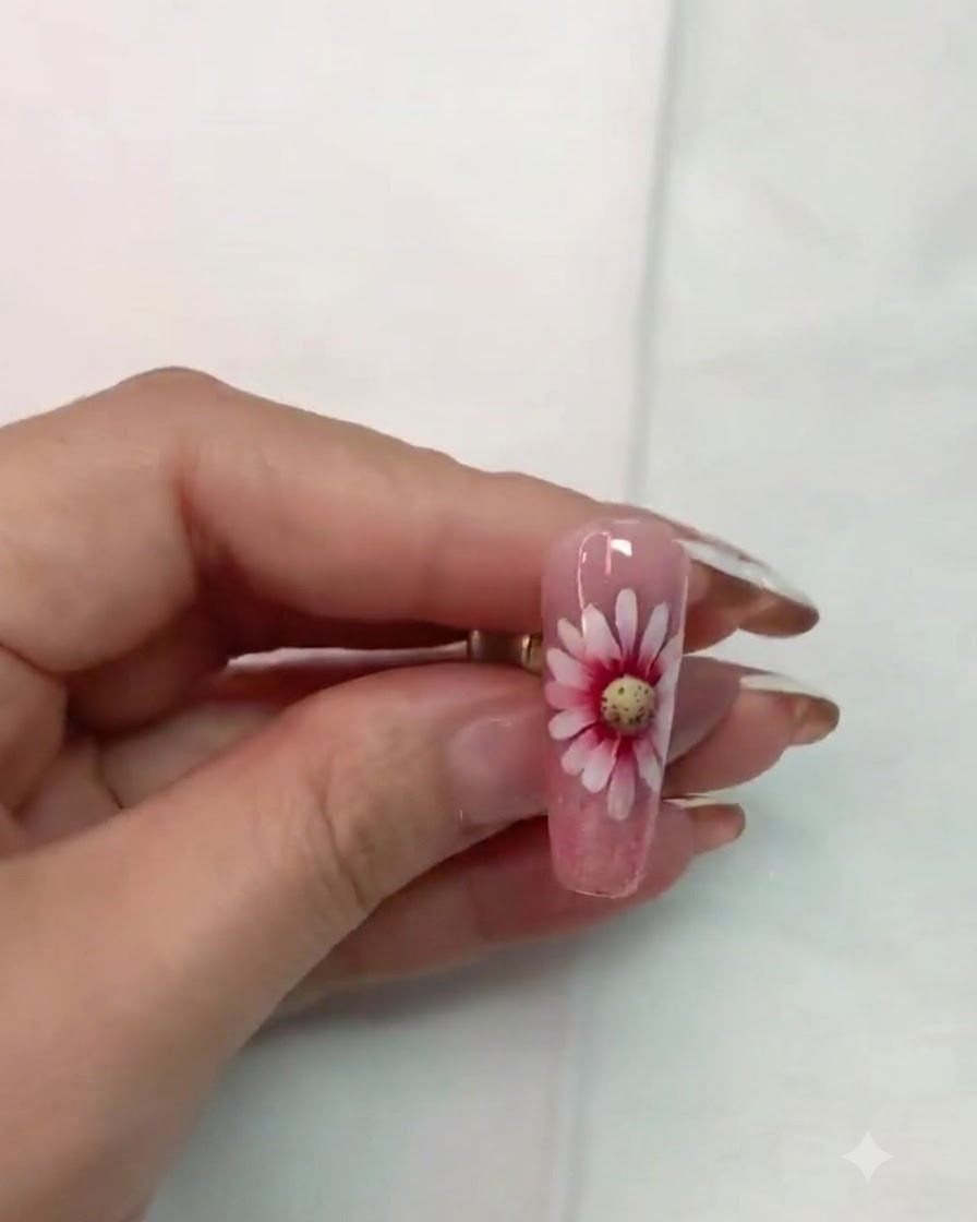 Un pinceau fin contournant et affinant soigneusement les détails autour du centre de la fleur de marguerite.