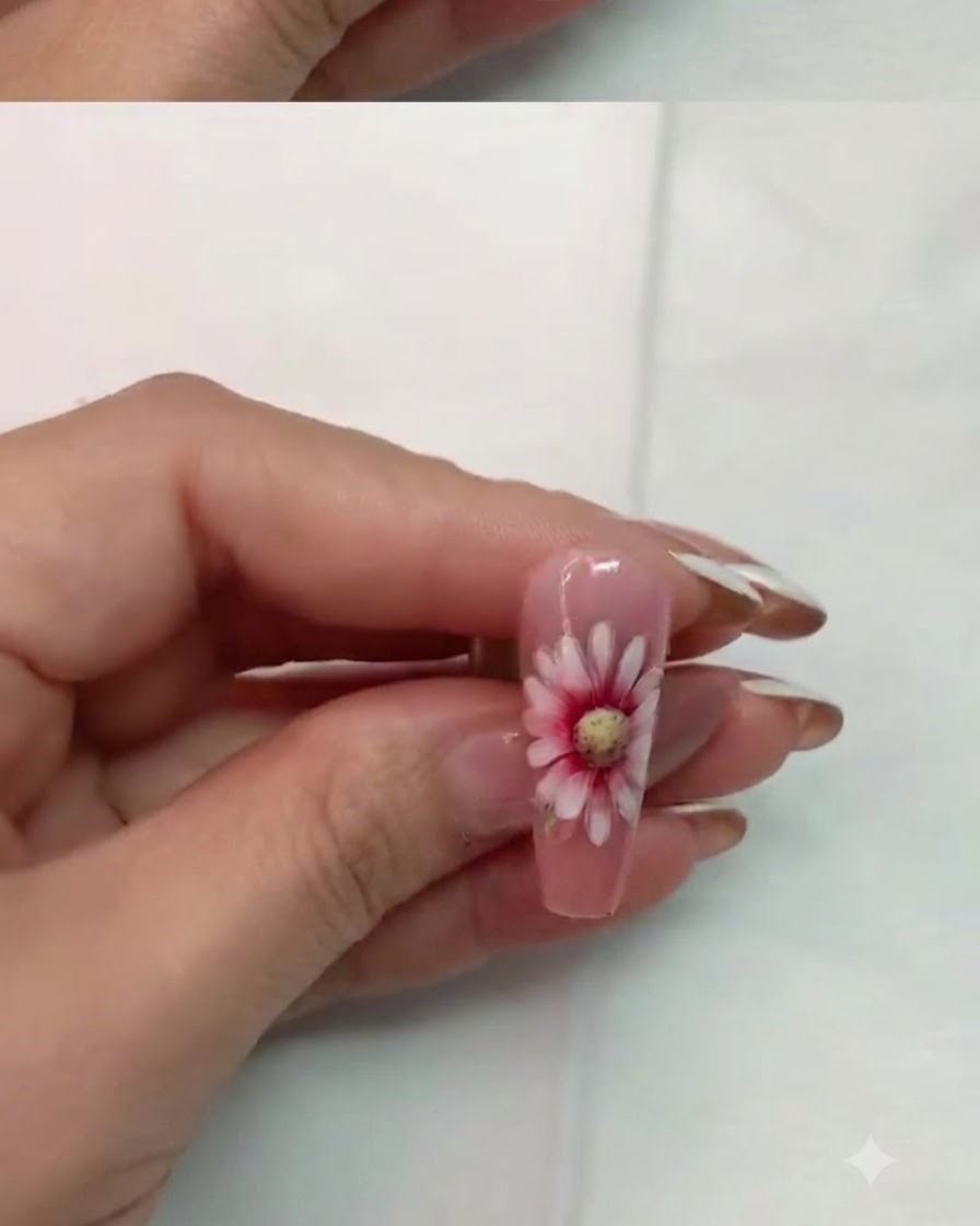 Un ongle avec un art de marguerite à double couche terminé en train de catalyser sous une lampe LED.