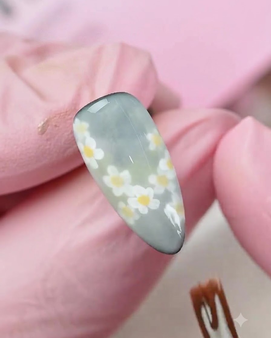 Un applicateur éponge tamponnant une couleur de dégradé subtile sur un ongle décoré à finition mate.