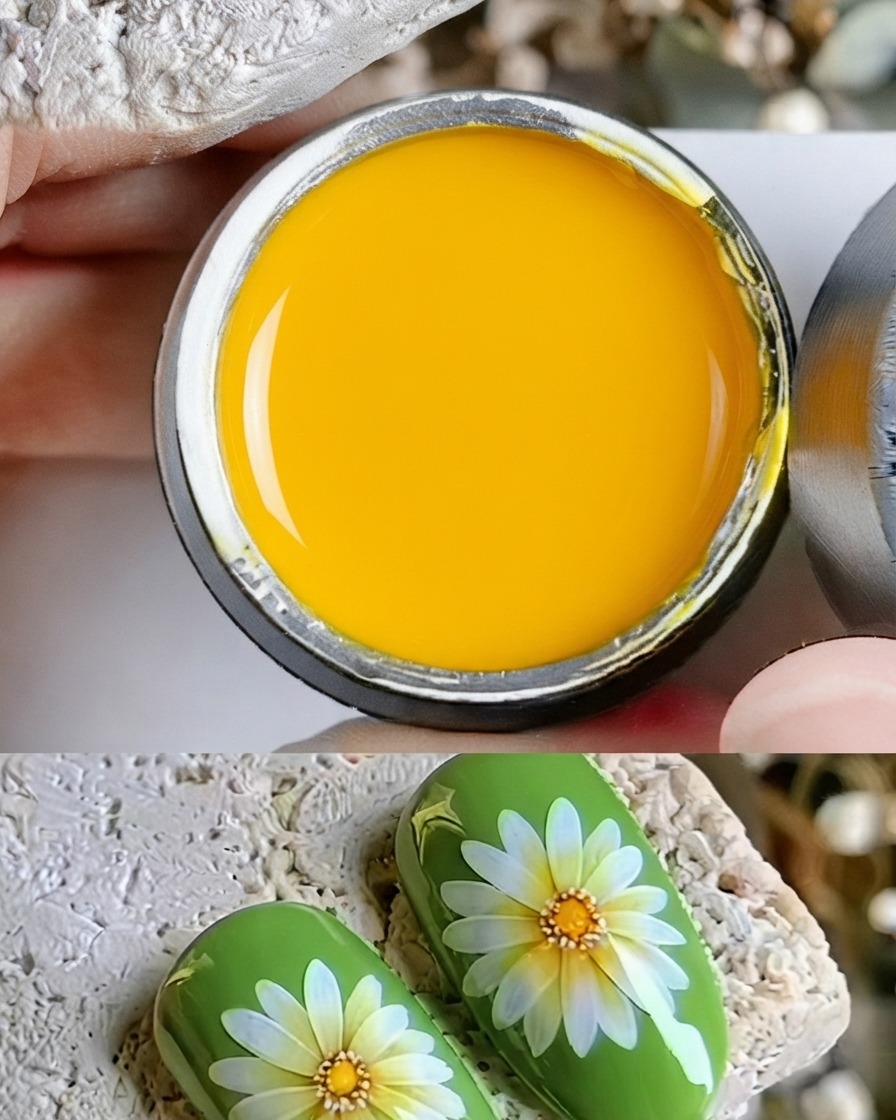 Gros plan dun pinceau fin déposant une goutte de gel jaune au centre dune marguerite peinte.
