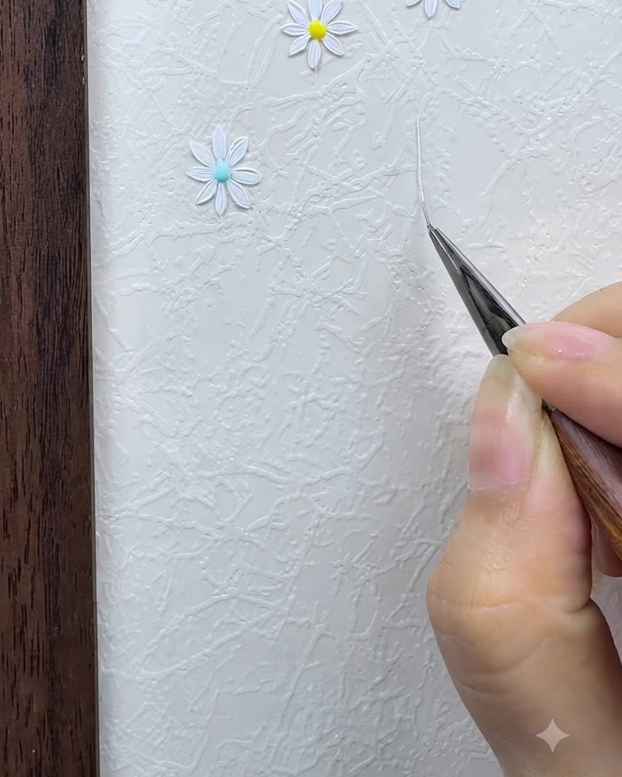 Un pinceau fin dessinant une fine grille en étoile blanche sur une surface texturée.
