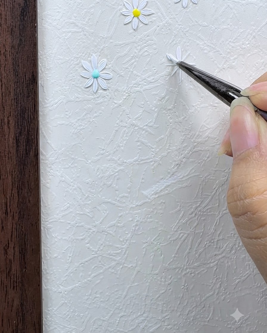 Un pinceau fin appliquant le premier pétale de marguerite blanc en utilisant une technique de point et de pression sur la grille.
