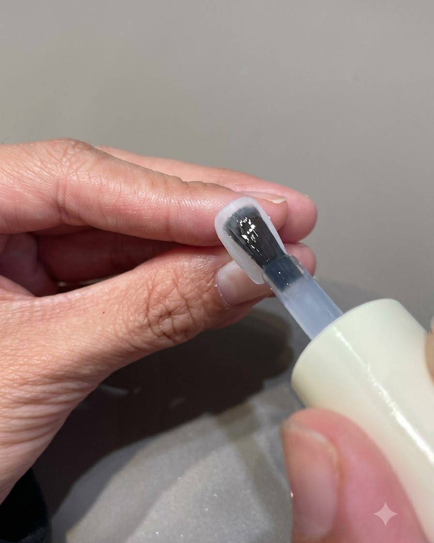 Une main positionnée à lintérieur dune lampe à ongles UV LED pour catalyser le produit en gel appliqué.