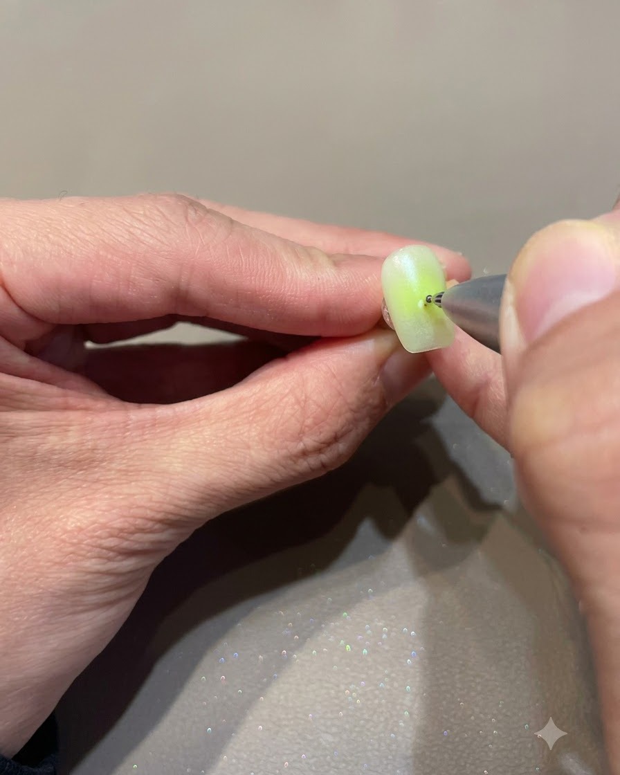 Un stylo de dotting appliquant un tout petit point sur une surface dongle décorée.