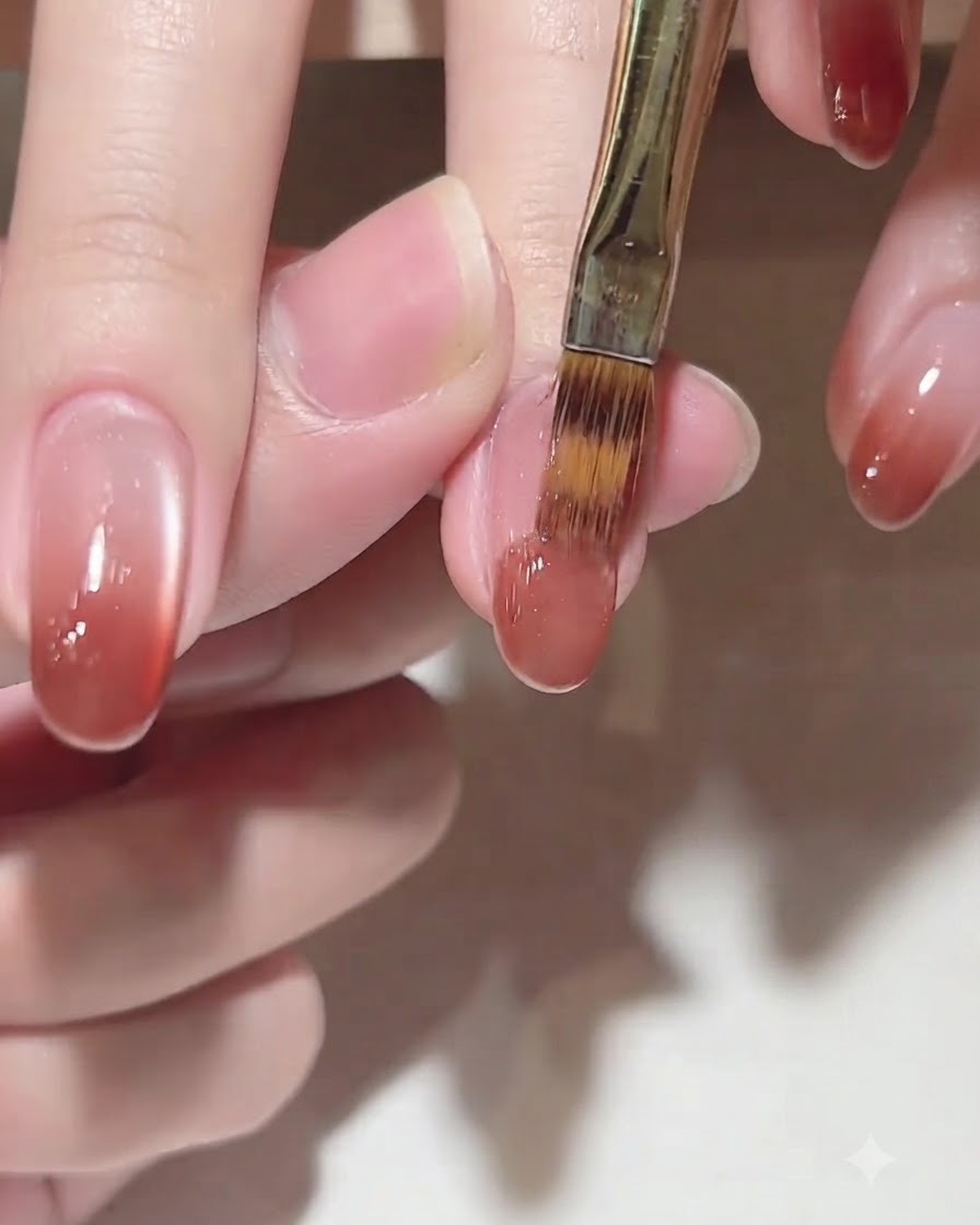 Un pinceau appliquant le gel de couleur C102 sur le bout de longle pour un effet ombré.