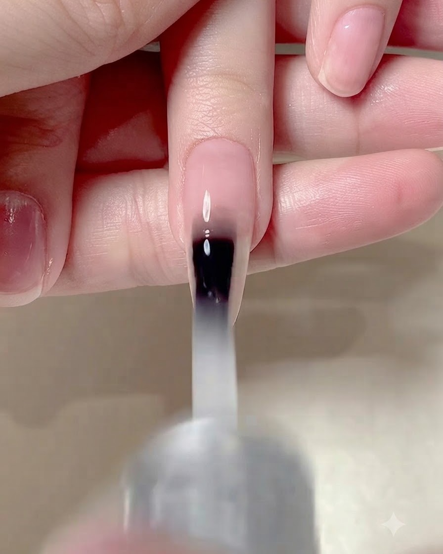 Un pinceau à ongles appliquant un top coat mat sur toute la surface dun ongle manucuré.