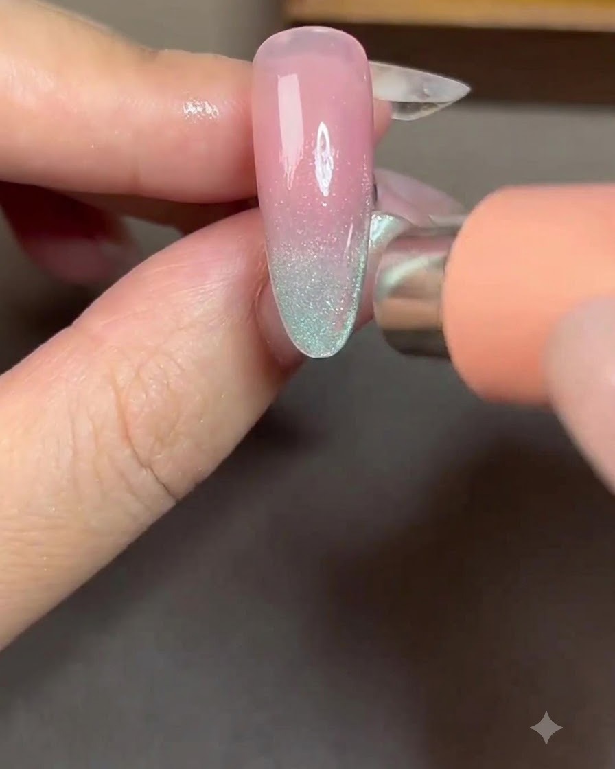 Un aimant positionné sur le côté droit dun ongle pour attirer les particules cat-eye en une bande lumineuse latérale.