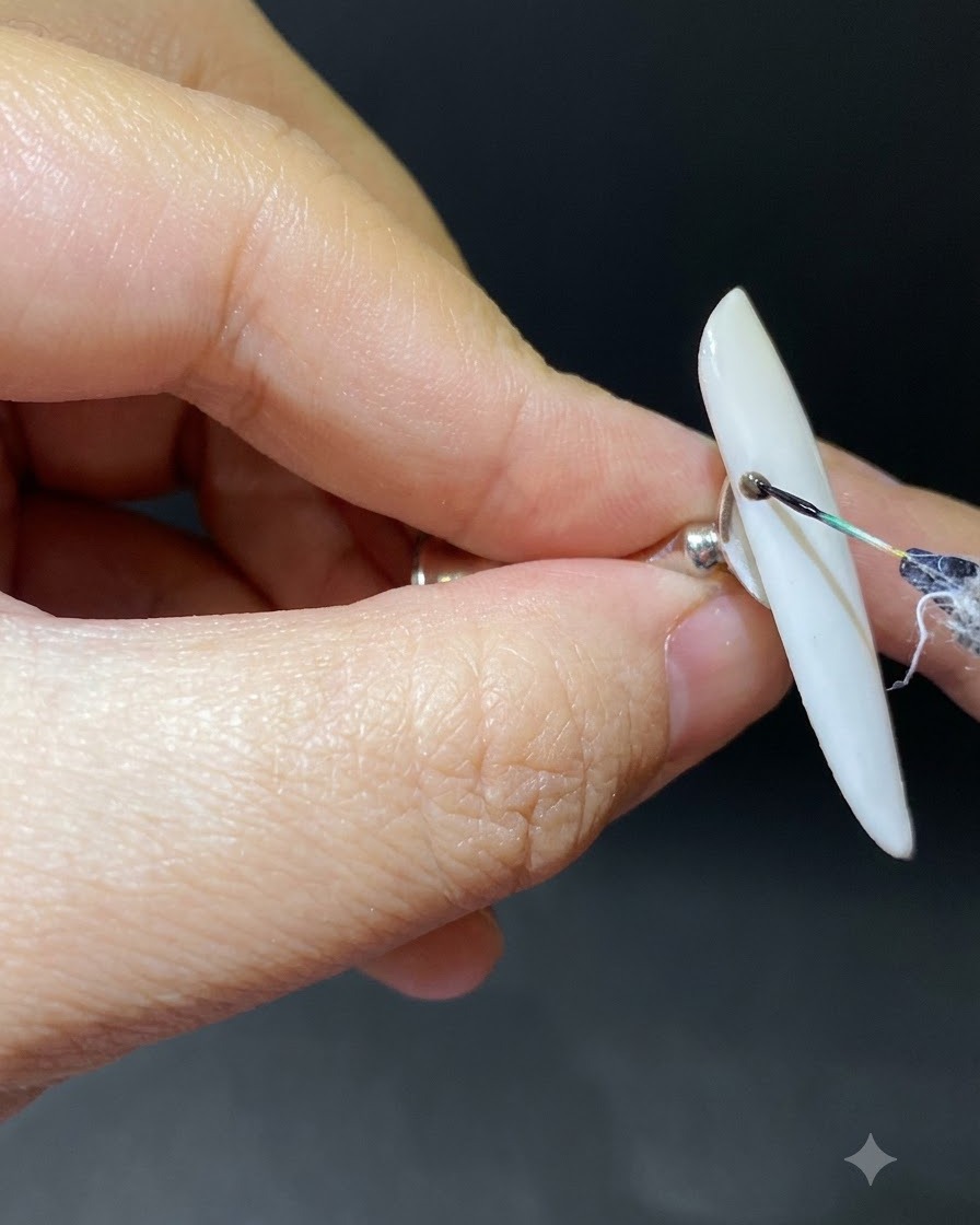 Un pinceau fin traçant une branche sombre et incurvée à partir de la cuticule sur un ongle en dégradé.