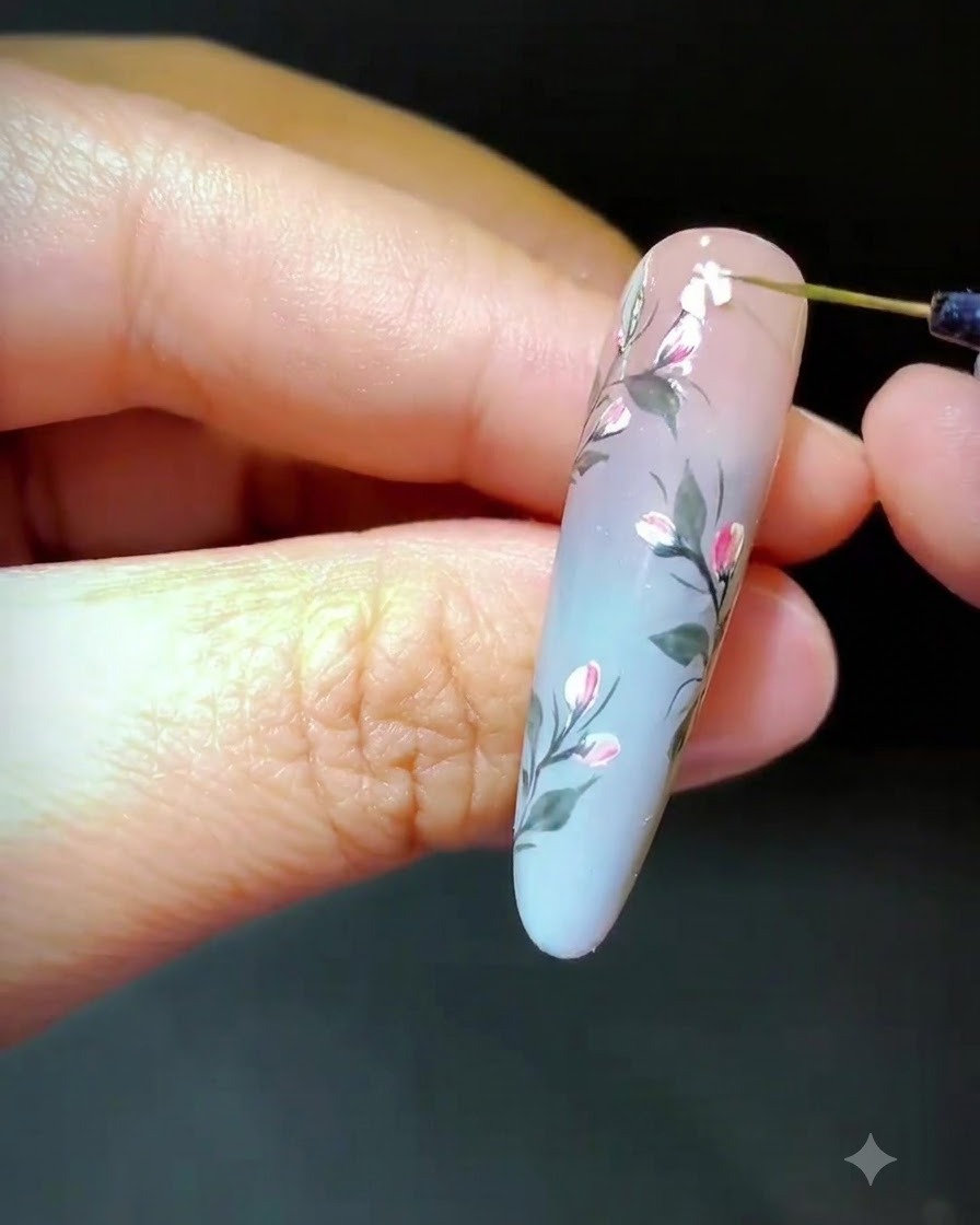 Un outil plaçant des fragments de coquillage sur du gel frais pour composer un motif floral.