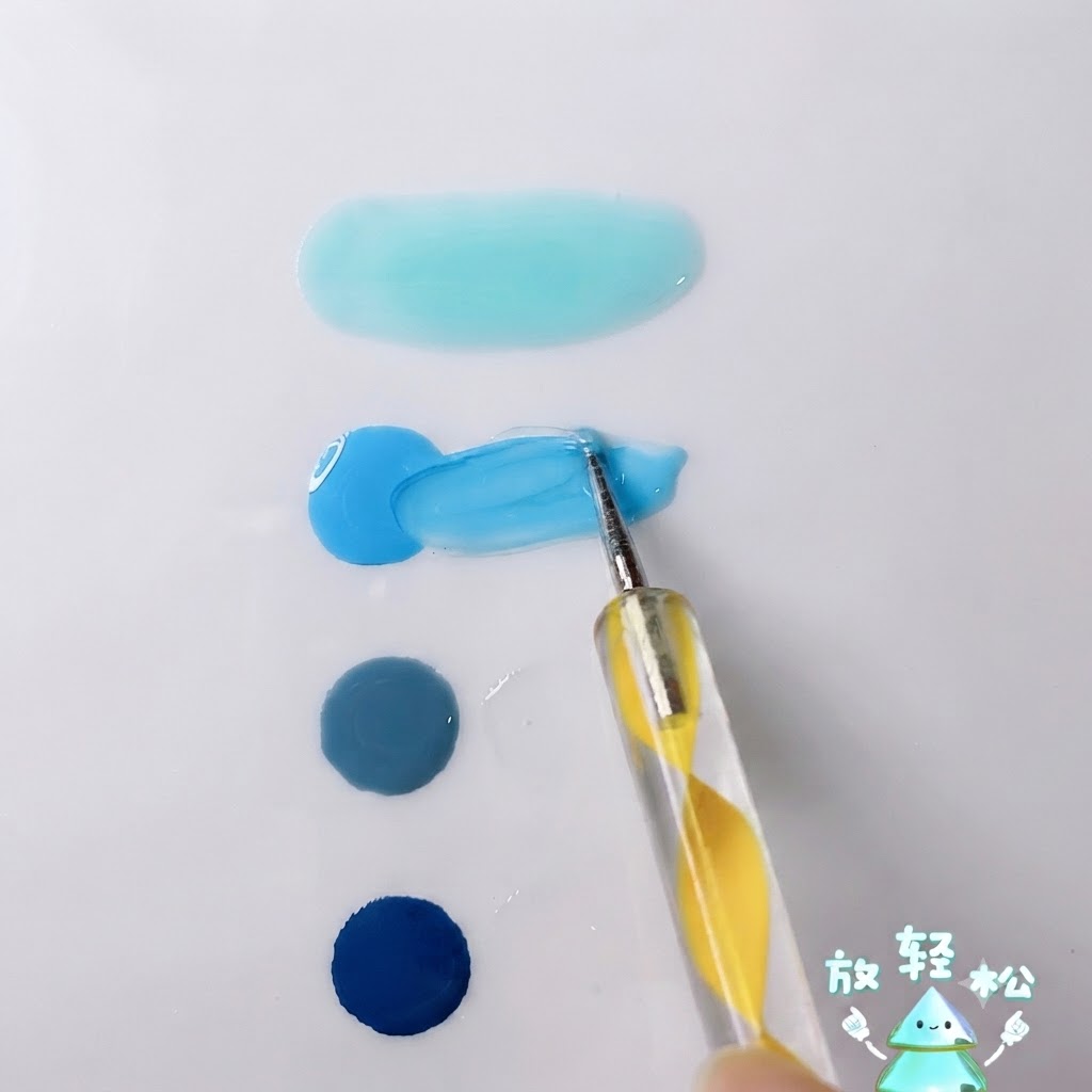 Un stylo à pointer mélangeant du gel bleu ciel vif avec du gel transparent sur la surface dune palette blanche.
