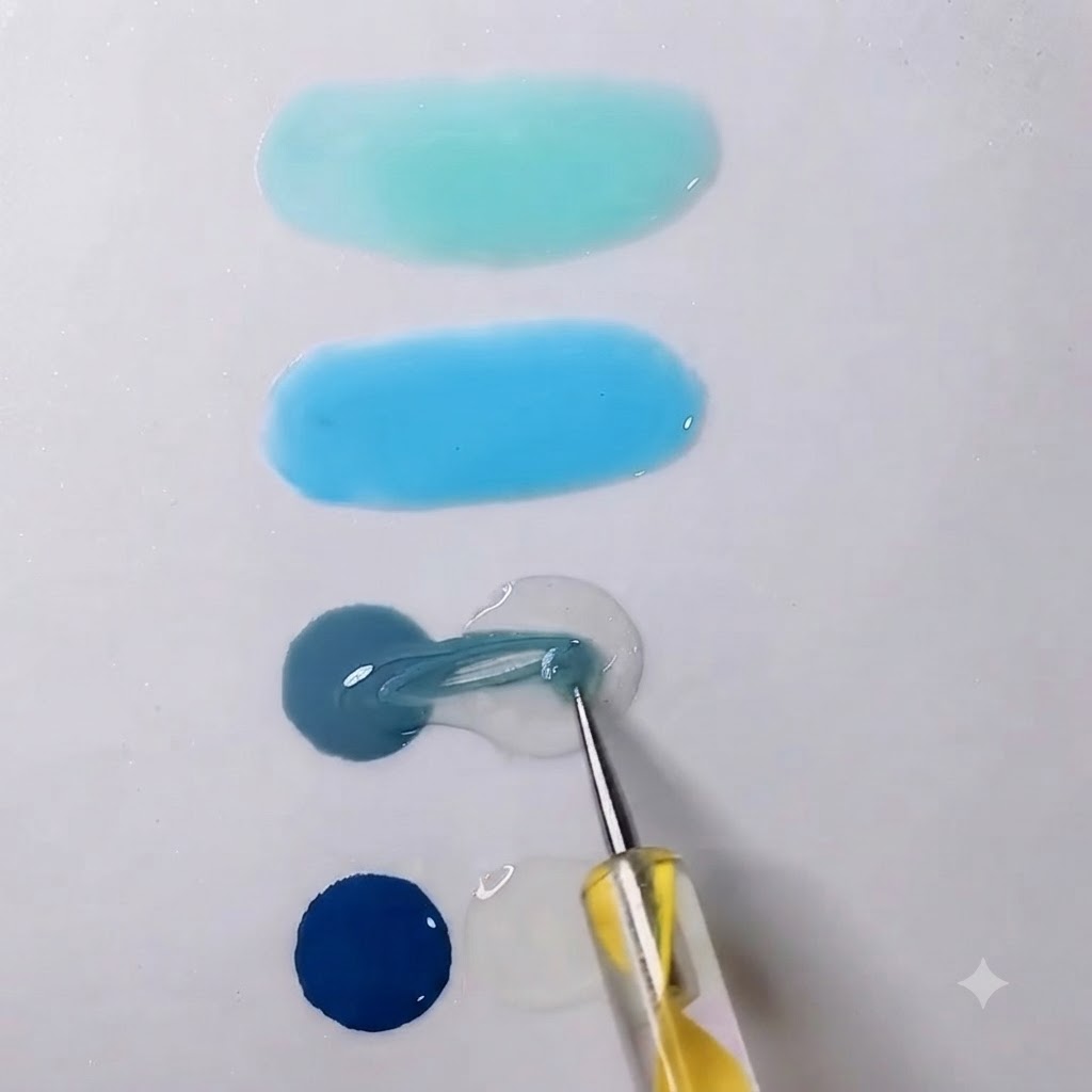 Un outil de mélange tirant du gel gris vers une goutte voisine de gel transparent sur une palette blanche.