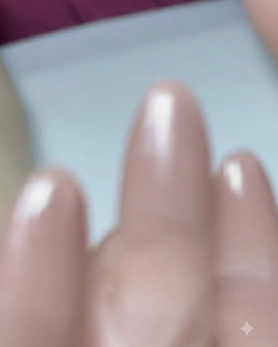 Gros plan dun pinceau à ongles appliquant du gel de base sur un ongle prépréparé en forme damande.