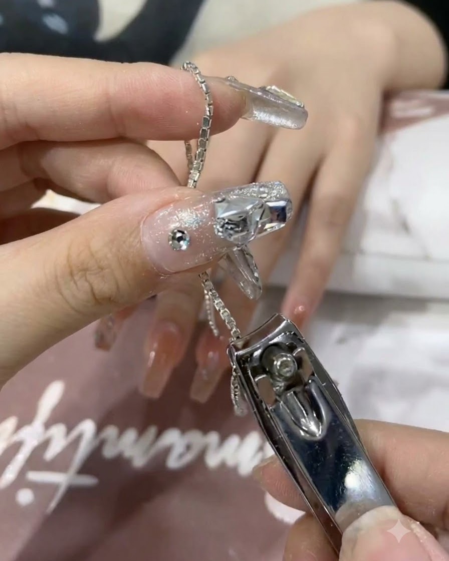 Gros plan de coupe-ongles coupant un petit segment de chaîne argentée brillante.