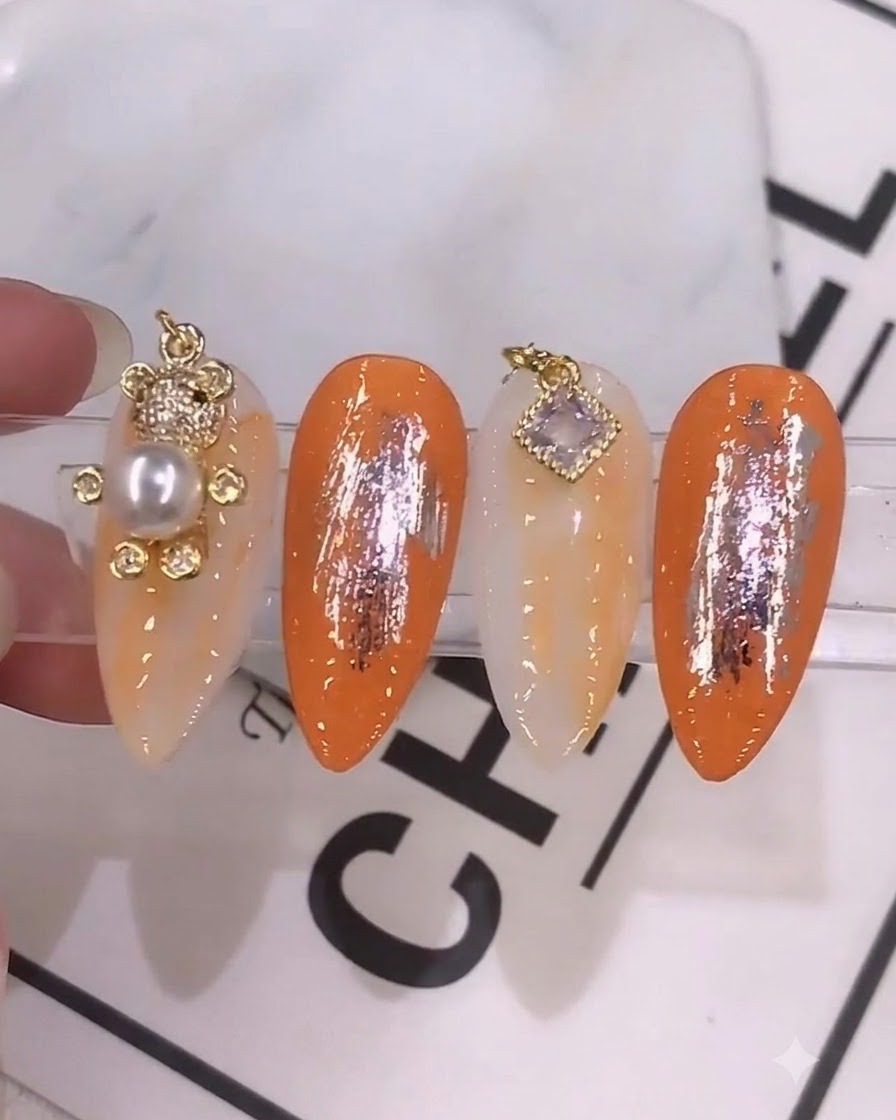 Gros plan détaillé dun pinceau à ongles appliquant un gel de couleur orange mélangé sur un ongle préparé.