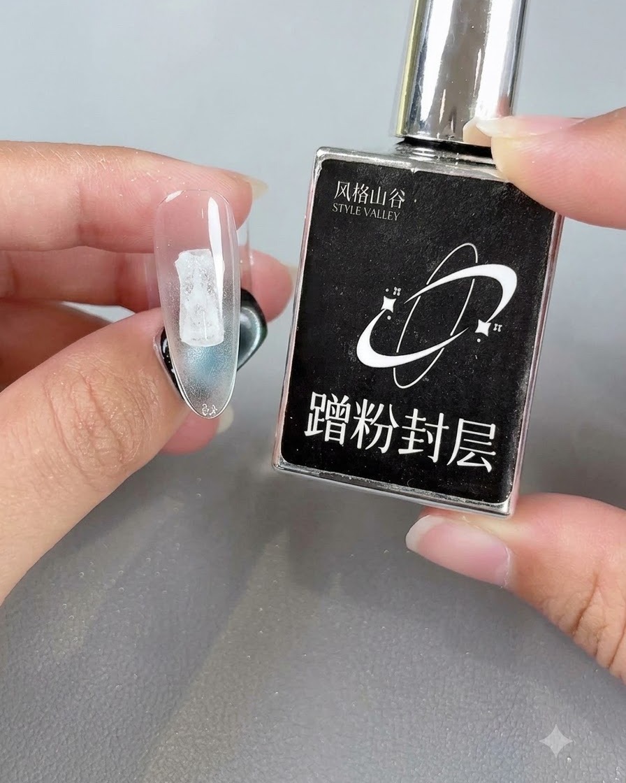 Une main tenant un flacon de produit noir à côté dun faux-ongle transparent affichant une couche de scellement catalysée.