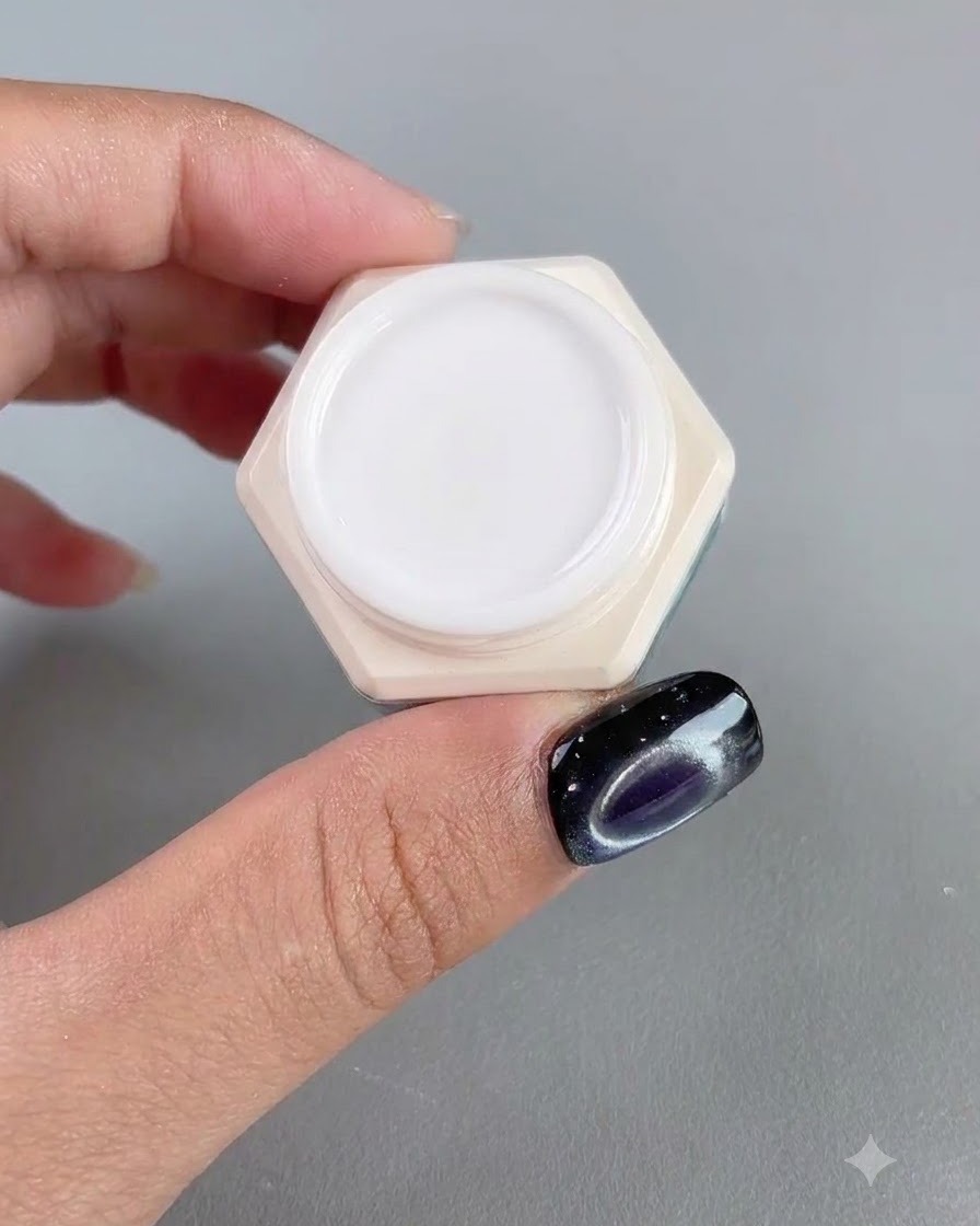 Un pot de gel pour ongles ambré hautement transparent présenté à côté dun doigt manucuré.