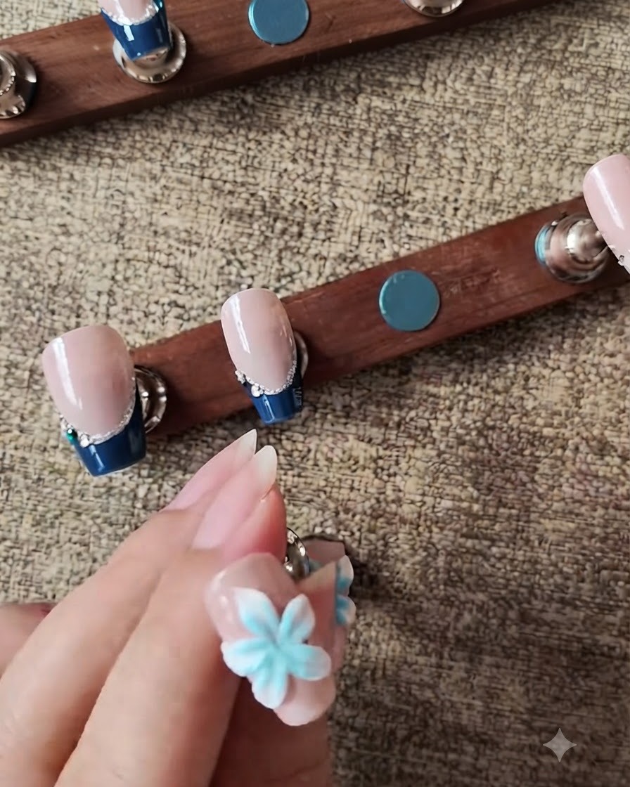 Une petite éponge appliquant par touches du gel bleu au centre dune fleur dongle 3D blanche.
