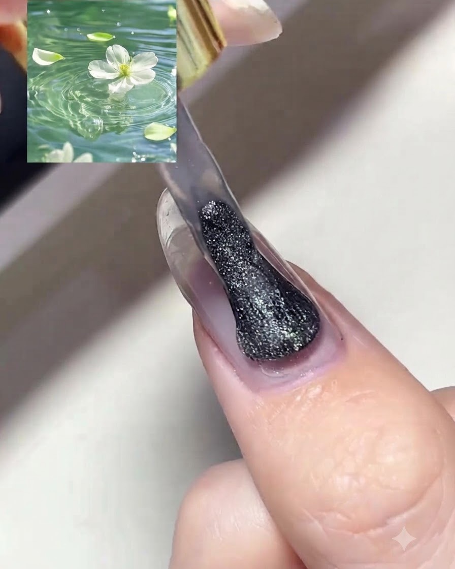 Un pinceau à ongle appliquant une couche de vernis gel œil de chat magnétique argenté scintillant sur un ongle préalablement préparé.