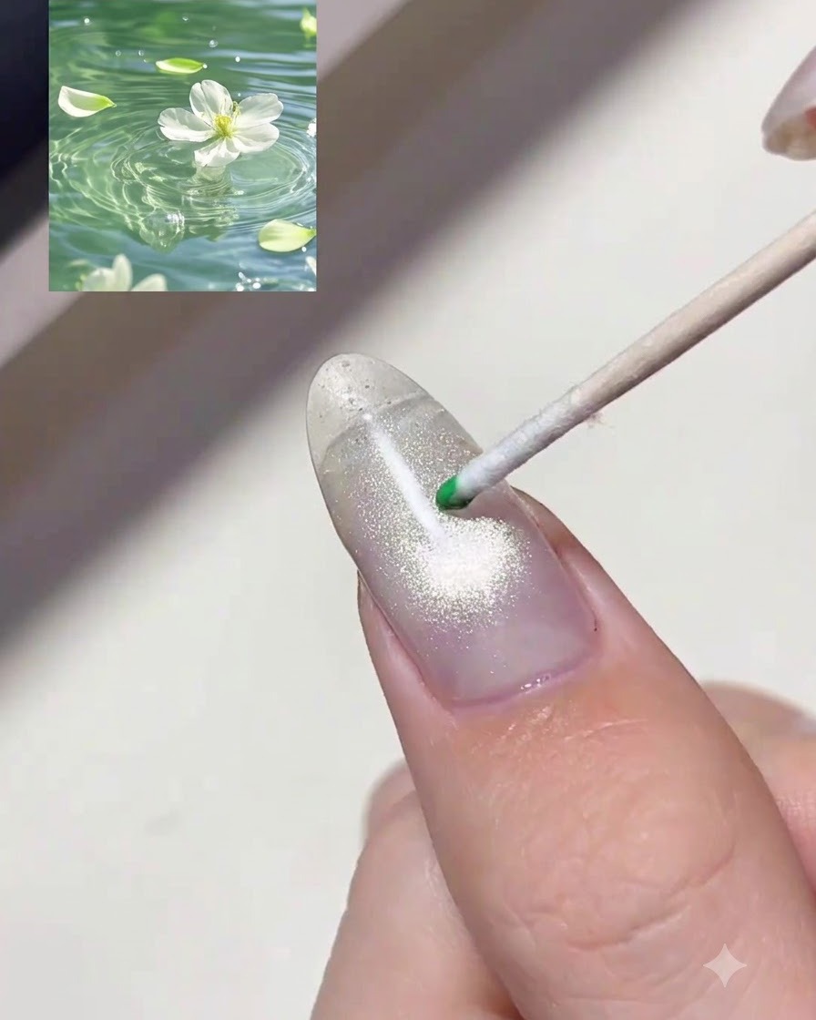 Un bâtonnet en bois déposant une goutte de gel teinté vert translucide sur un ongle scintillant.