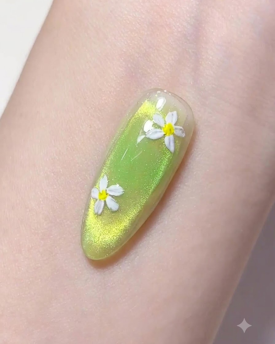 Un pinceau liner fin prélevant une goutte de gel de construction transparent au-dessus dun ongle manucuré en vert.