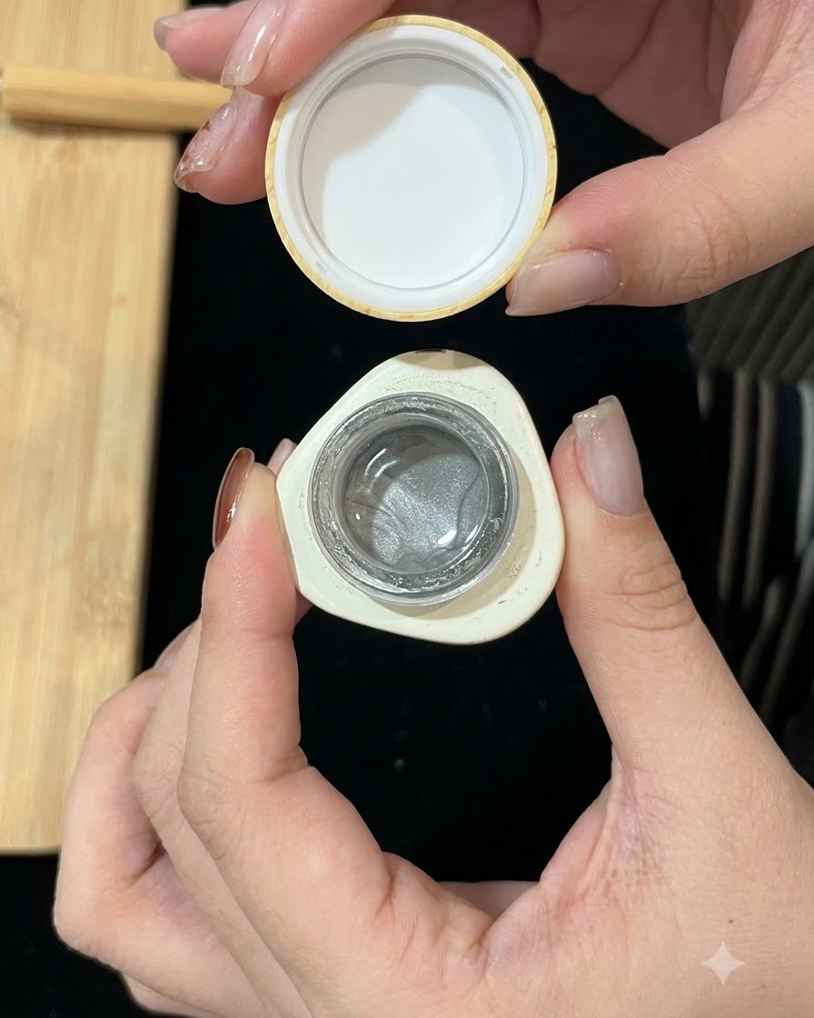 Un petit pot de gel cat-eye magnétique argenté ouvert, montrant la formule scintillante à lintérieur.