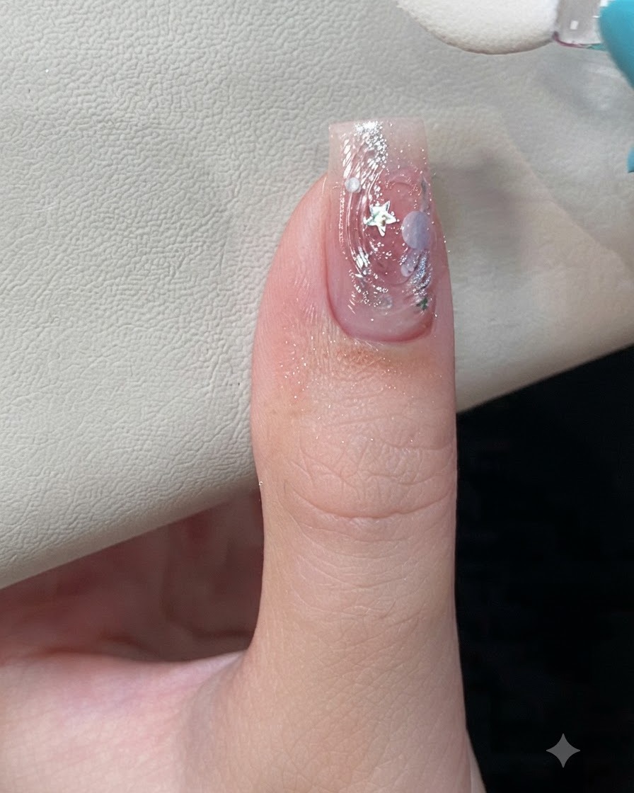 Gros plan dun applicateur éponge frottant de la poudre aurora irisée sur les textures dondulation deau 3D surélevées dun ongle manucuré.