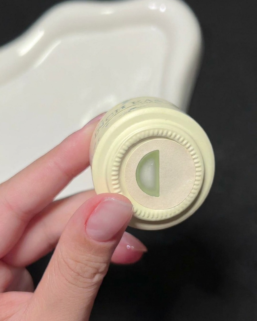 Une main tenant un flacon de vernis gel vert INCH EASY, montrant létiquette dindication de couleur sur le dessus.
