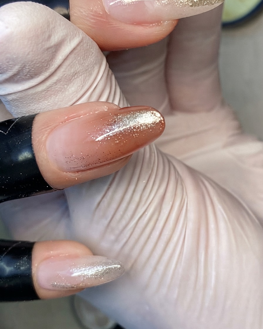 Doigts positionnés à lintérieur dune lampe UV/LED pour catalyser la couche de top coat ultra-brillant finale.