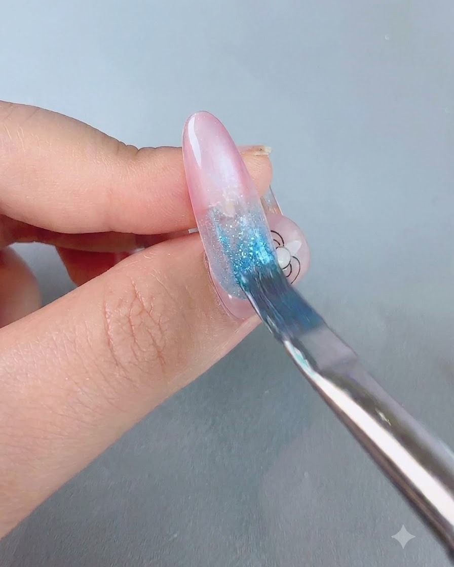 Un pinceau à dégradé doux étirant du gel bleu vers le bas sur une base dongle rose.