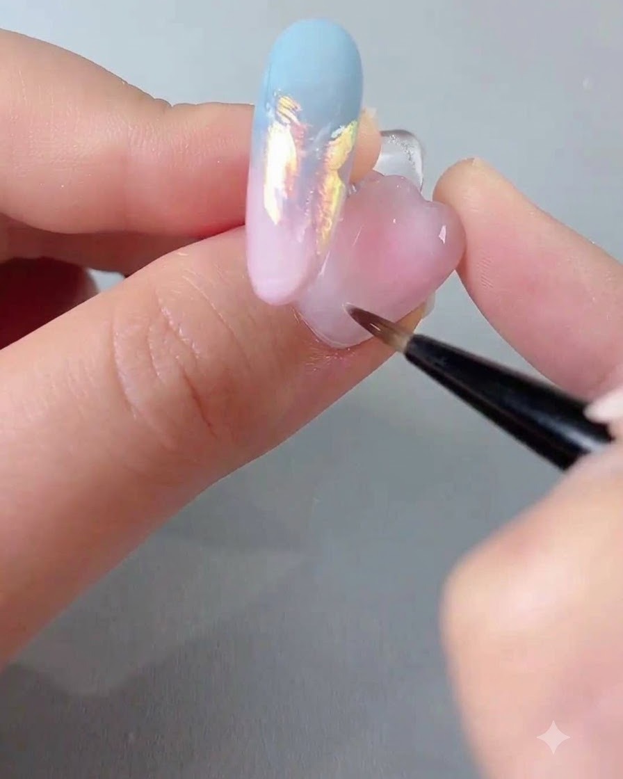 Un pinceau de vernis à ongles appliquant une couche de gel scellant transparent sur un ongle décoré.