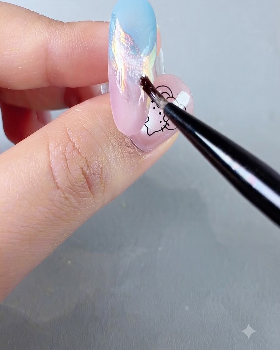 Un petit pinceau de détail appliquant de la poudre pailletée scintillante colorée sur un ongle dégradé pastel.