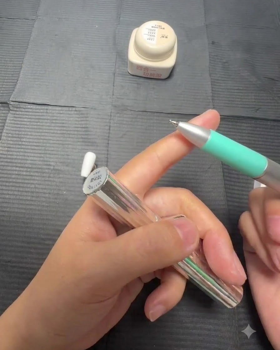 Vue rapprochée dun pinceau appliquant du gel blooming transparent sur un ongle peint en blanc.