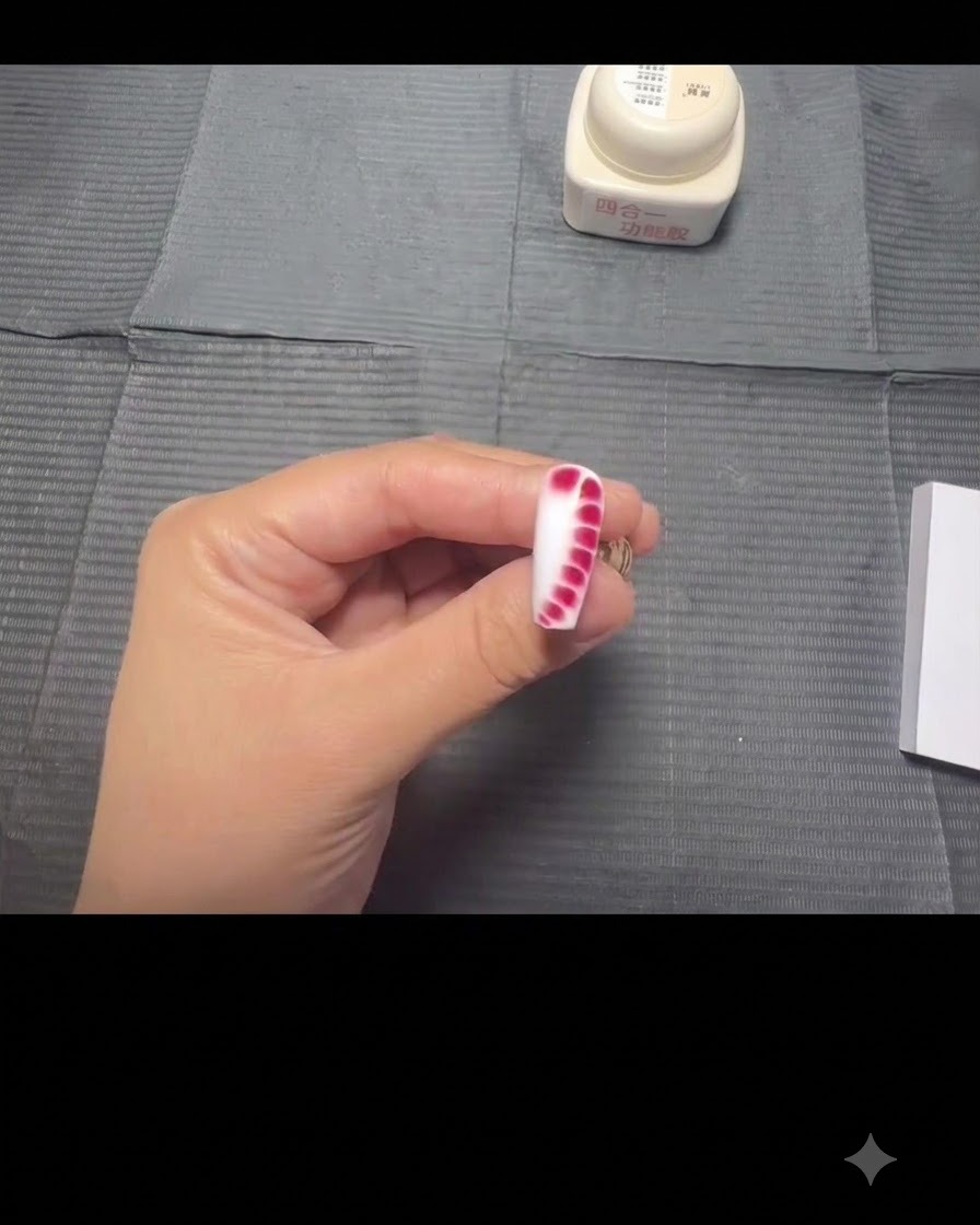 Le nail art peau de serpent entièrement étalé où les points rouges se sont magnifiquement propagés sur la base blanche, prêt à être catalysé.