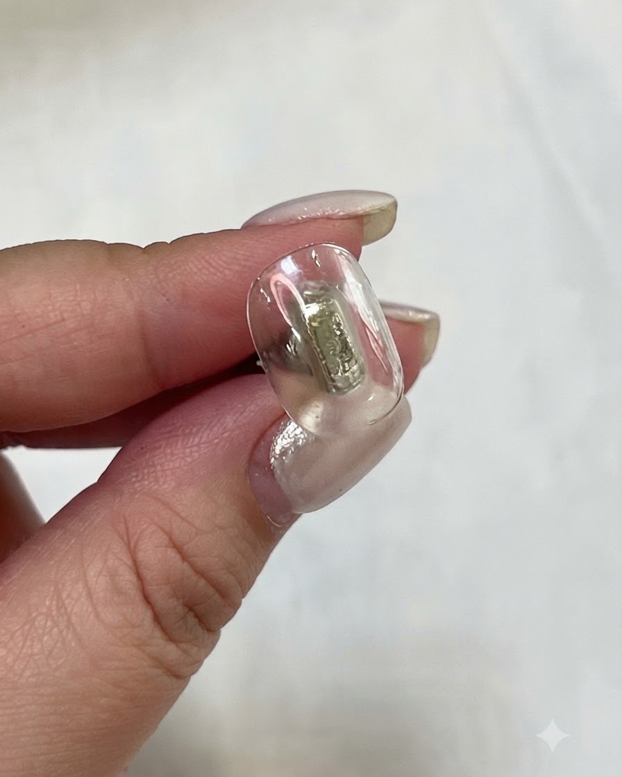 Un pinceau plat à gel appliquant du gel jaune translucide sur une plaque dongle.