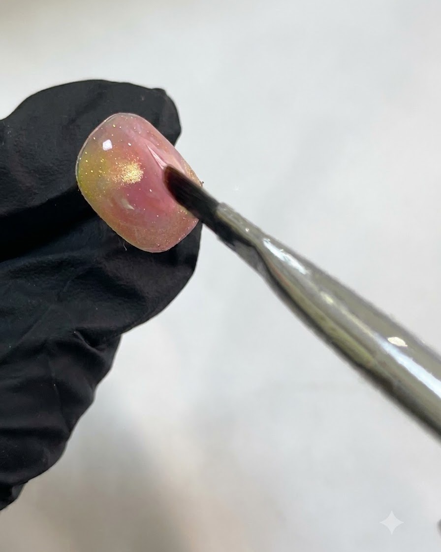 Un ongle placé sous une lampe de catalysation UV/LED après lapplication des accents aquarelle blancs translucides.