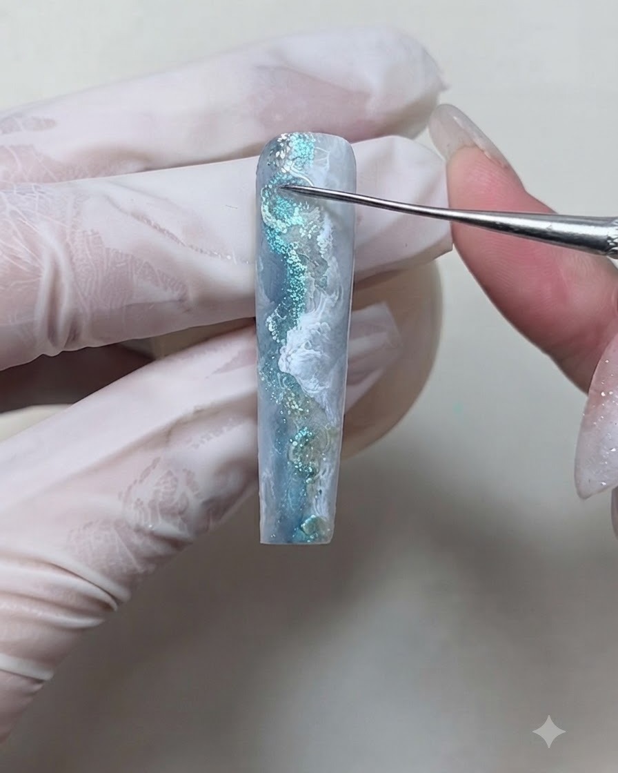 Un outil de dotting appliquant du gel transparent épais pour former des gouttelettes deau dimensionnelles en relief sur un ongle.