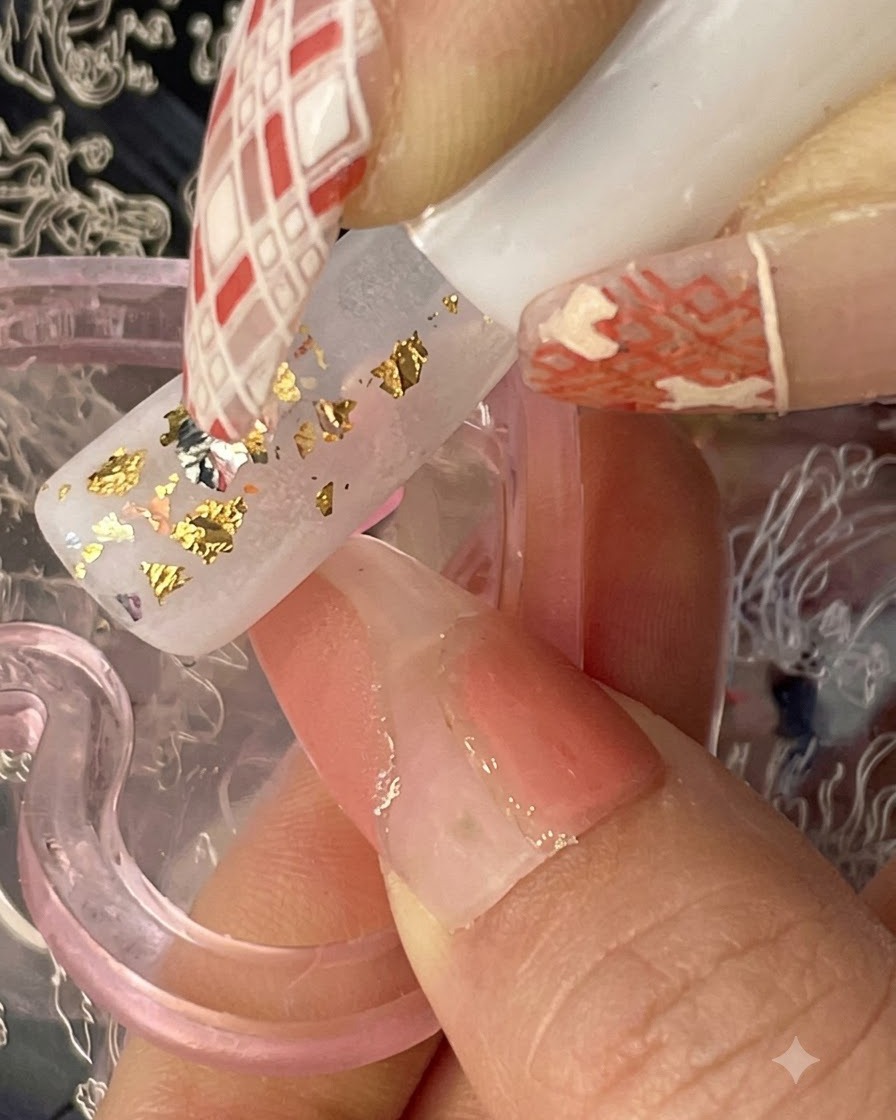 Pinceau appliquant un gel translucide marron-orange par touches irrégulières sur une base avec des éclats dor.
