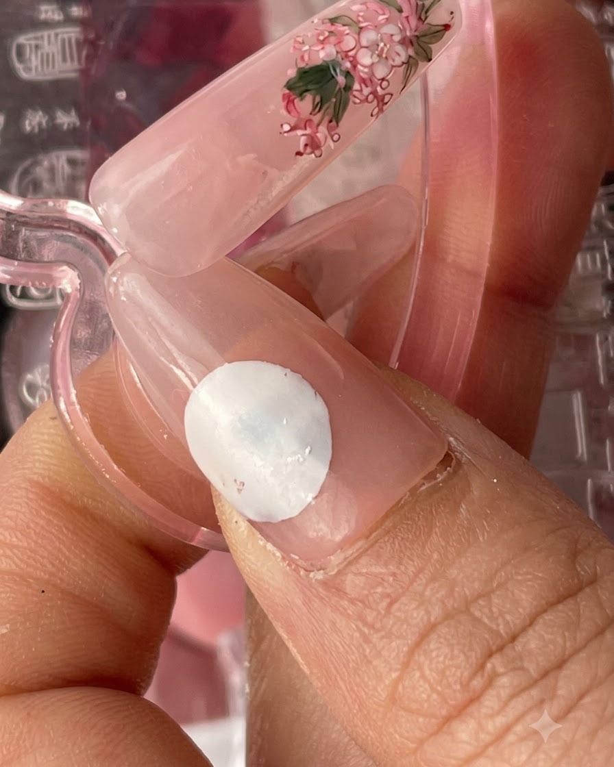 Une capsule dongle finie avec une base rosée et un art floral délicat, montrée à côté dun échantillon dongle séparé.