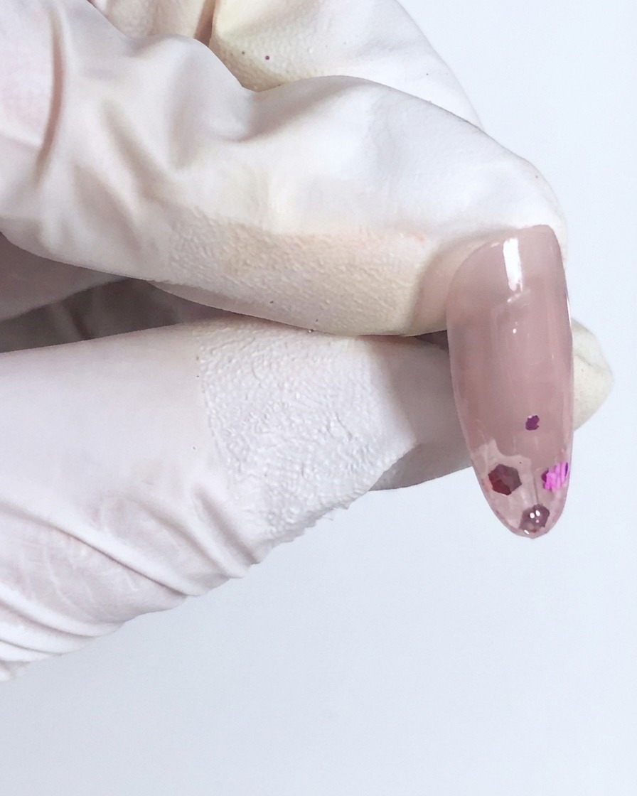 Une capsule dongle brillante avec la première couche de sequins entièrement encapsulée sous une fine couche de gel transparent.