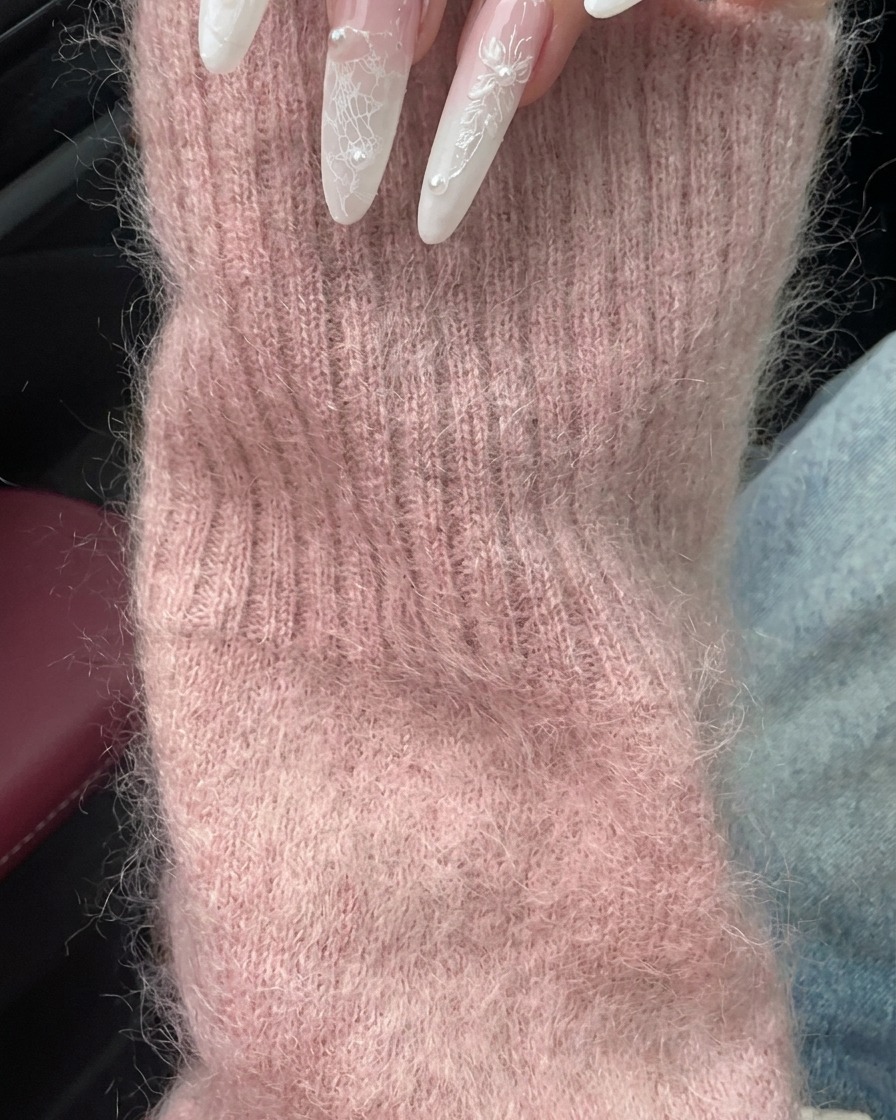 Main positionnée près de lintérieur dune voiture mettant en avant les ongles et une bague en perles assortie.