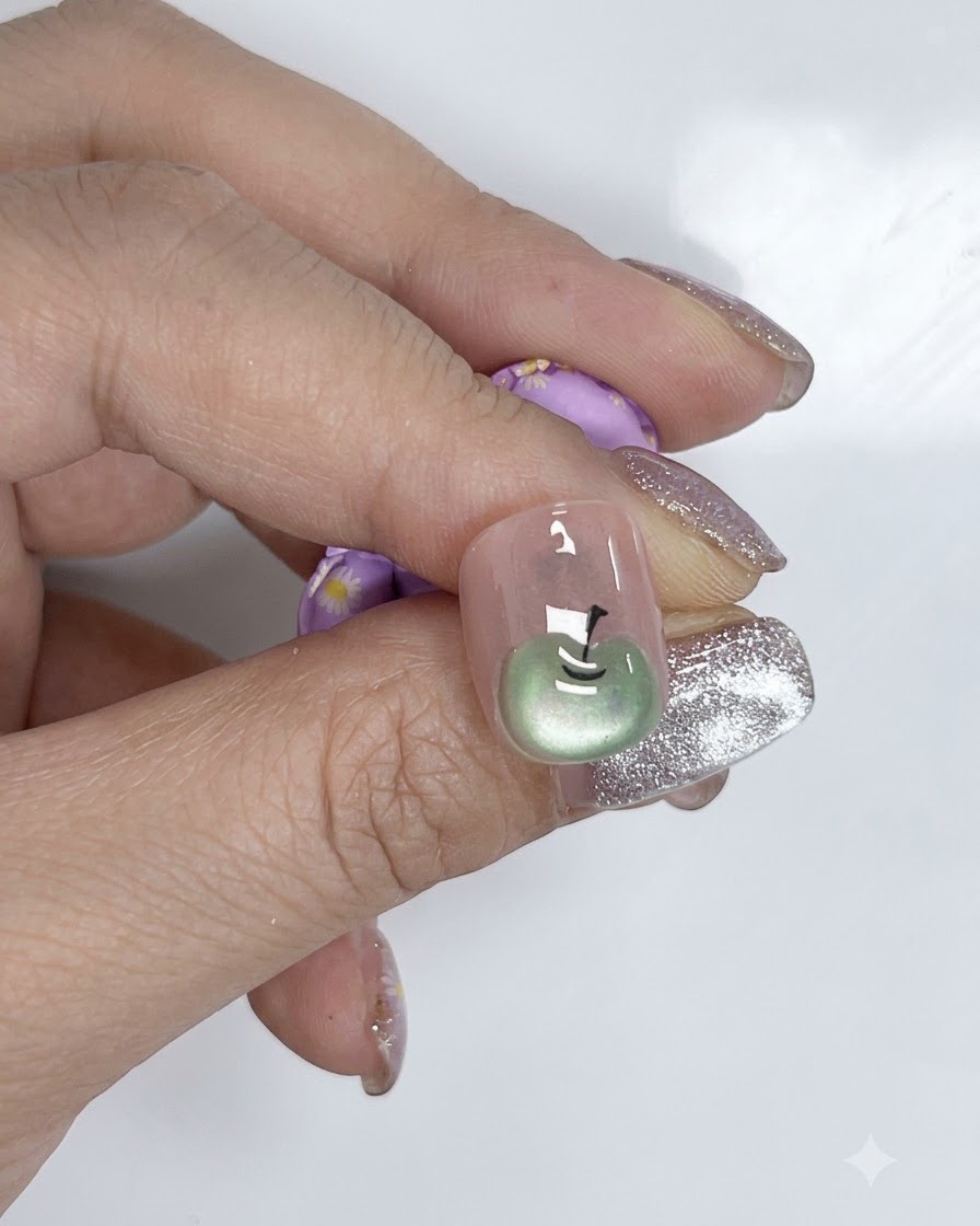 Un pinceau à ongle appliquant une couche lisse de vernis nude sur une plaque dongle naturelle.